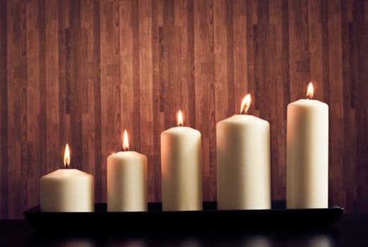 white candles on warm atmosphere and old wooden background
