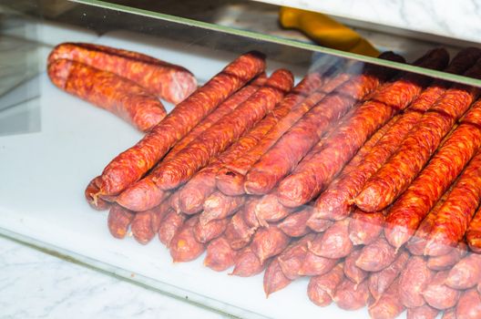 Smoked homemade sausage in the sales counter in a butcher's shop.
