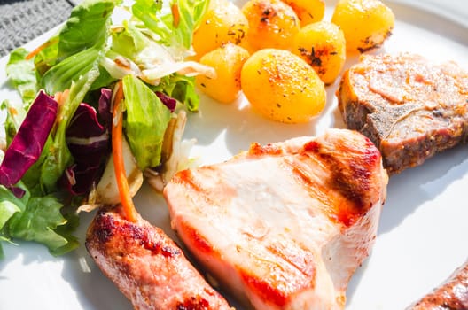 Tasty lunch with meat, fried potatoes and salad.