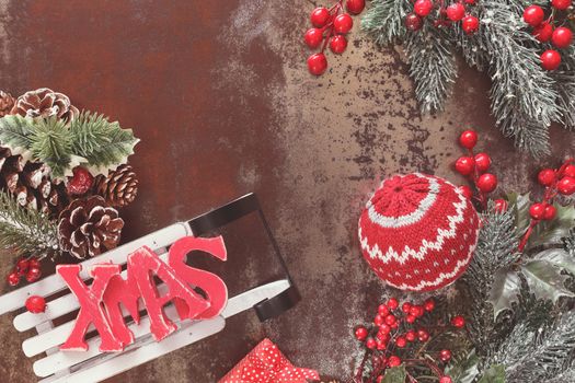 Christmas background with woolly Christmas decoration and XMAS letters on sledge, rustic wood background with blank space, vintage style