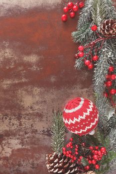 Christmas frame of fir tree branches, berry and woolly Christmas ornaments decoration. Vintage style with blank space