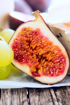 Delicacy cheese and fruit plate on table, closeup