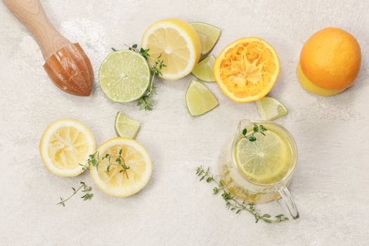 Citrus fruits, wooden squeezer and a glass of lemonade on granite table, top view. Macro, selective focus