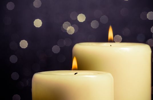 close-up of candles with flame on bokeh background and space for text