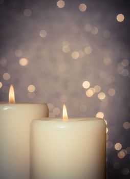 candles with flame on bokeh background and space for text