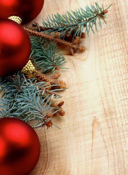 Corner Border of Blue Spruce Branch with Fir Cones and Red Baubles closeup on Wooden background