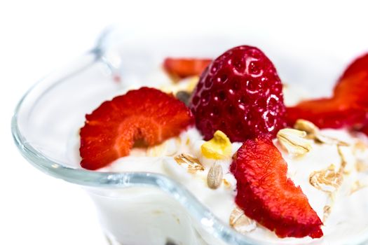 Glass of Muesli with strawberries and yogurt isolated on white