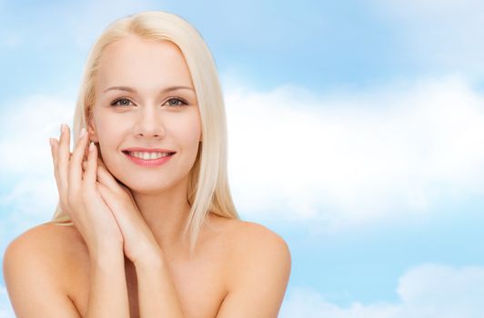 health and beauty concept - face and hands of happy woman