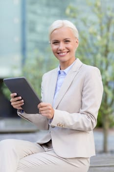 business, education, technology and people concept - smiling businesswoman working with tablet pc computer on city street