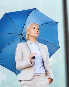 business, bad weather and people and concept - young serious businesswoman with umbrella outdoors