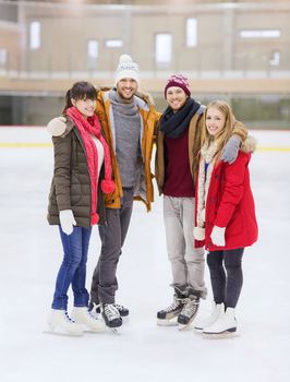 people, friendship, sport and leisure concept - happy friends on skating rink