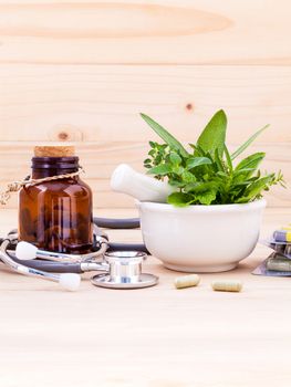 Capsule of herbal medicine alternative healthy care with stethoscope on wooden background.