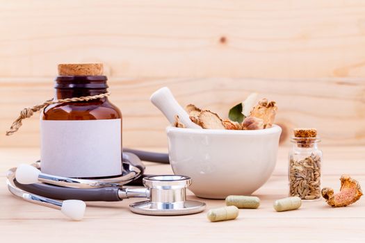 Capsule of herbal medicine alternative healthy care with stethoscope on wooden background.