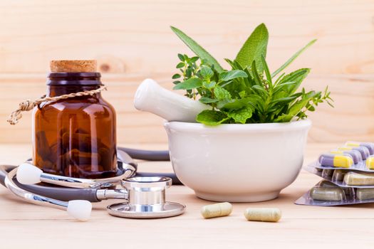 Capsule of herbal medicine alternative healthy care with stethoscope on wooden background.