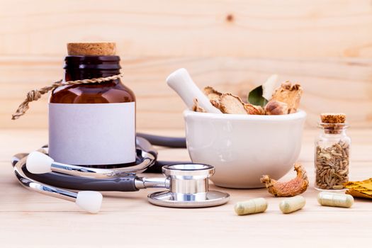 Capsule of herbal medicine alternative healthy care with stethoscope on wooden background.
