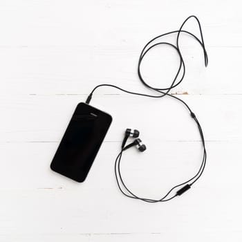 cellphone with earphone over white table