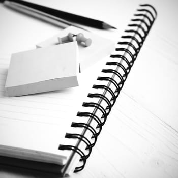 notepad with office supplies on white table black and white style