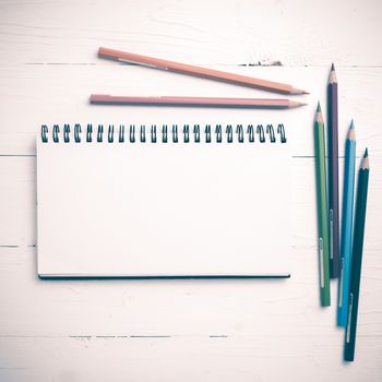 notepad with color pencil on white table view from above vintage style