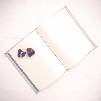 heart on notebook over white table vintage style