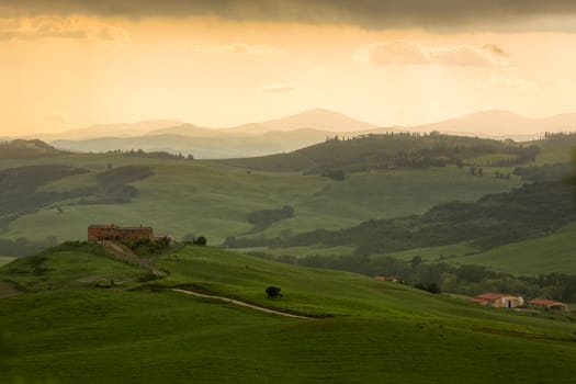 Tuscany landscape with farmhouse and yellow sky, Pienza, Italy