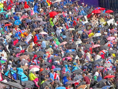 LONDON, ENGLAND - August 3, 2012 - Umbrellas go up in a crowd watching the athletics in the summer olympics in London 2012
