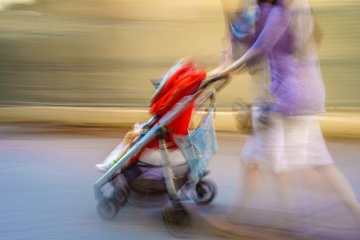 A blue as mom rushes with her bright red stroller through a city maze.