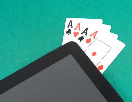 poker cards near digital tablet pc on green table, concept of  poker online