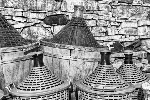 Demijohns of wine in a stone cellar.