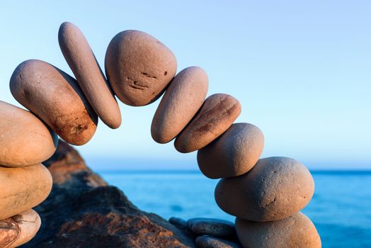 Curve of pebbles in the form of a arch on the coast