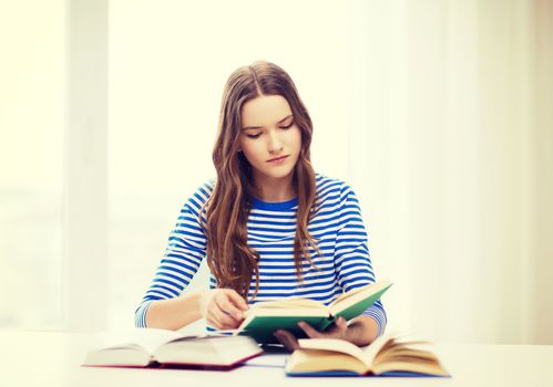 education and home concept - concecntrated student girl with books