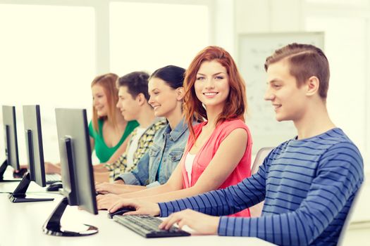 education, technology and internet - smiling female student with computer studying at school