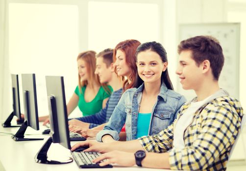 education, technology and internet - smiling female student with computer studying at school