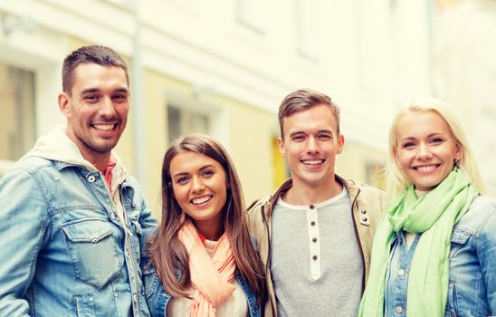 travel, vacation and friendship concept - group of smiling friends in city