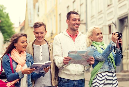 travel, vacation, technology and friendship concept - group of smiling friends with city guide, photocamera and map exploring city