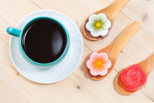 Thailand tradition ,Flower Dessert Coconut Jelly on wood 
spoon with black coffee
