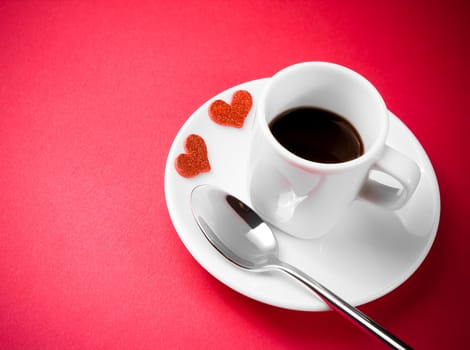 decorative red hearts near cup of coffee on red table with space for text, concept valentine day