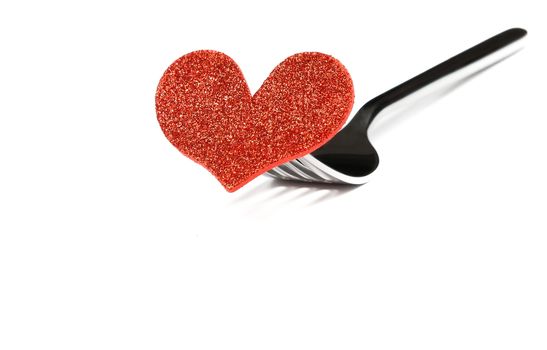 decorative red heart near a fork on white background with space for text, concept valentine day dinner 