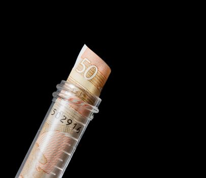 euro banknotes in graduated test tube, the cost of medical health on a black background