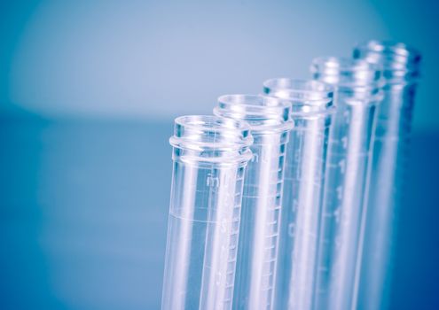 detail of the test tubes in laboratory on blue light tint background with space for text