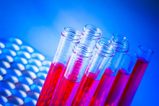 test tubes with red liquid in laboratory on blue light tint background