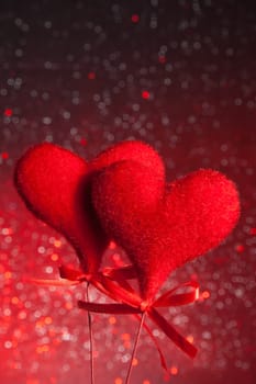 two red velvet hearts on red tint light bokeh background with space for text, concept of valentine day 