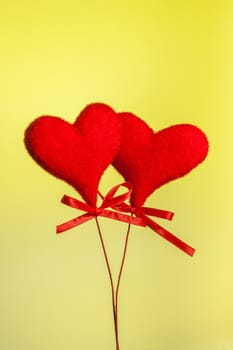 two red velvet hearts on yellow tint light background with space for text, concept of valentine day 