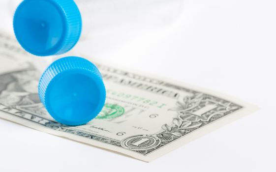 test tubes on dollar under white background, cost of medical health care