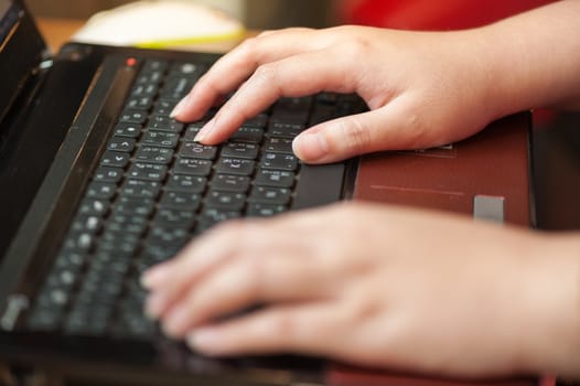 Female hand typing on laptop keyboard