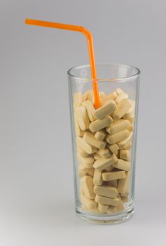 Conceptual vitamin drink with orange straw
