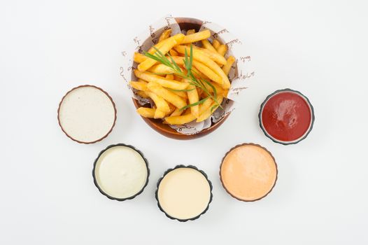 French fries in wood bowl garnished with Japanese bamboo leaves with 5 sauce tartar sauce, wasabi mayo sauce, mayonnaise, thousand island sauce, and ketchup