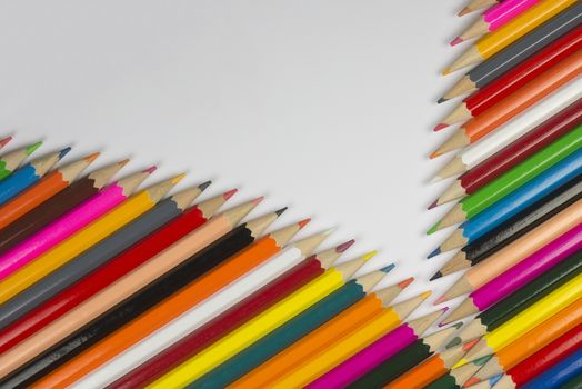 Abstract composition of a set cedar wooden colour pencils against a white background in zipper style
