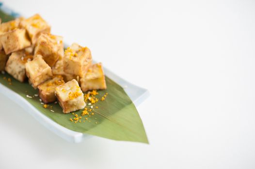 Fake fried tofu (using eggplant replace to tofu) on Japanese bamboo leaf with small cup of plum sauce
