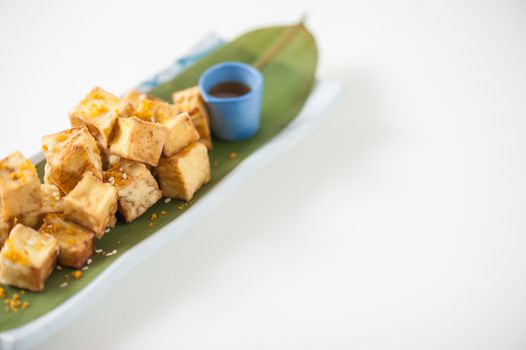 Fake fried tofu (using eggplant replace to tofu) on Japanese bamboo leaf with small cup of plum sauce