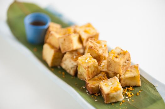 Fake fried tofu (using eggplant replace to tofu) on Japanese bamboo leaf with small cup of plum sauce